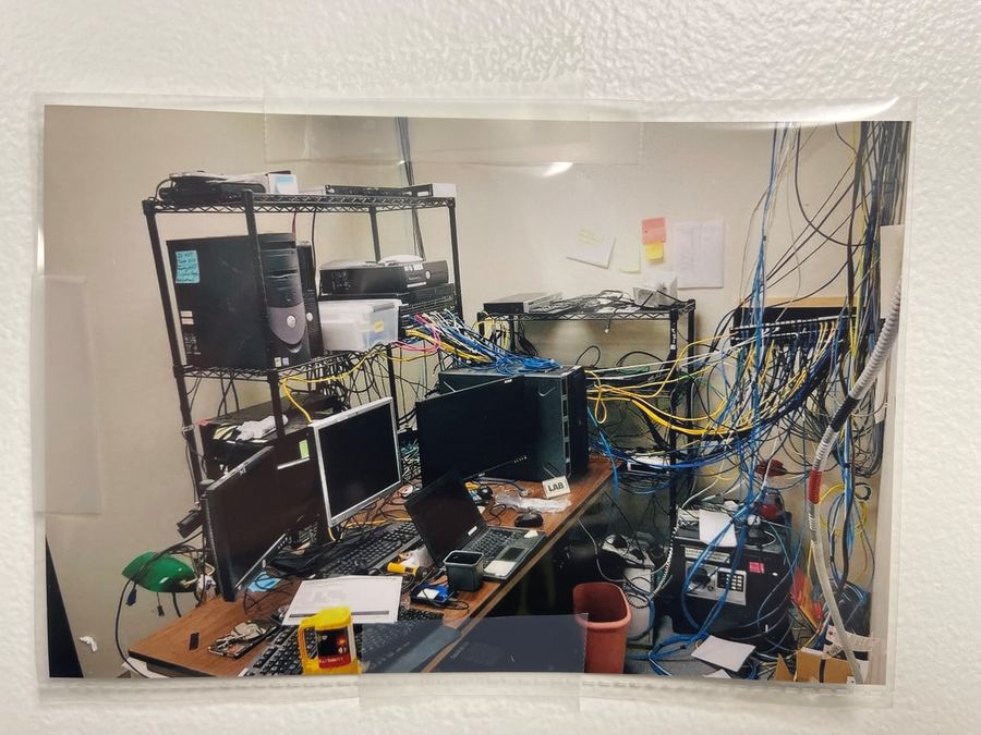 LAB Security server room before CompDAT renovation - tangled cables and wire shelving